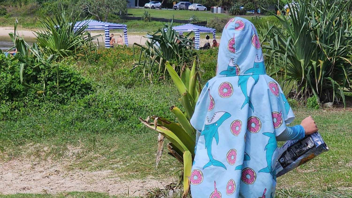 Enjoying a bag of chips at the beach in a new sand free beach essential feeding frenzy aussie hoodie