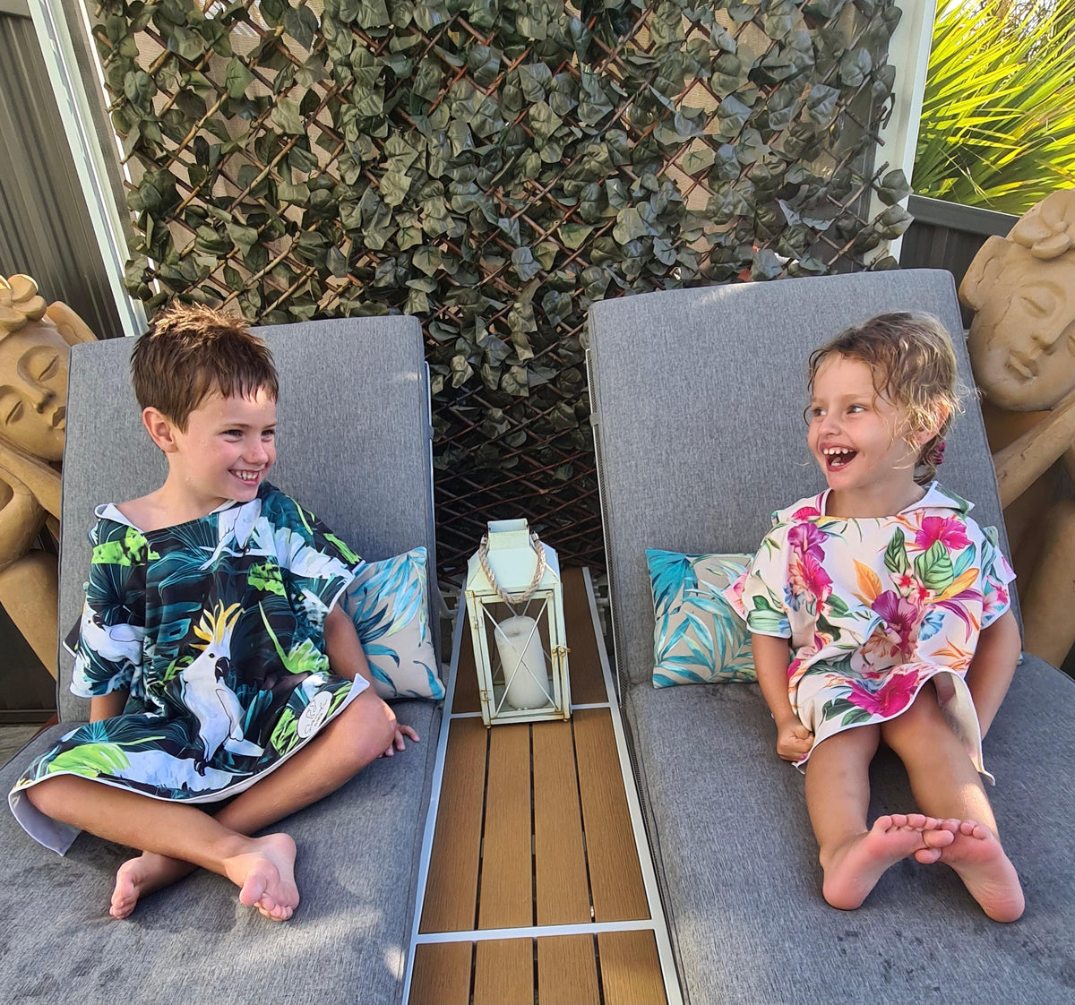 Two siblings relaxing after a swim on their lounge chairs one with Bird of Paradise and the other in Turtle Cove 