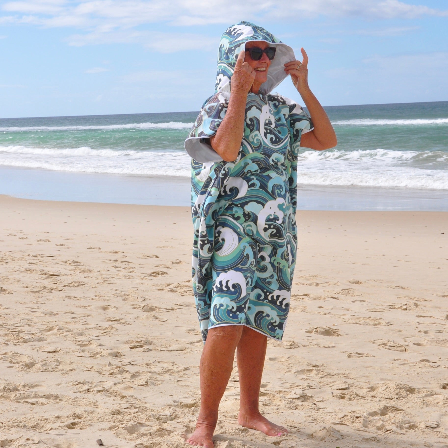 Adult wearing Wipeout sand-free beach hoodie showing comfort and style, with hood up